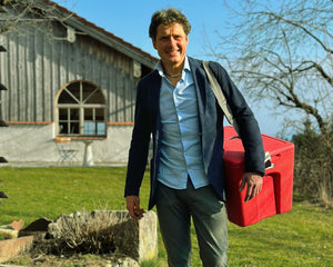 Johannes Ebert, Gründer von CAGOON, mit einem roten AEROSTUFFY vor der Manufaktur in Prutting bei Rosenheim – Made in Germany aus Überzeugung.