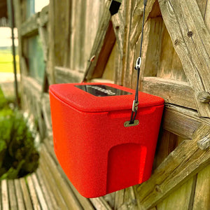 Box in Größe M rot hängend vor Holzwand