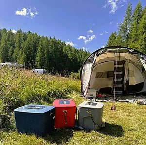 Anwendung Camping mit AEROSTUFFY Box M rot, blau und grau vor einem Zelt